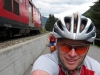 Emily and Cris are passed by a train while riding towards Oberalppass (Switzerland)