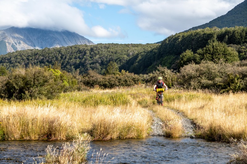 Katie coming up to a stream (Bikepacking Poulter Jan 2024)