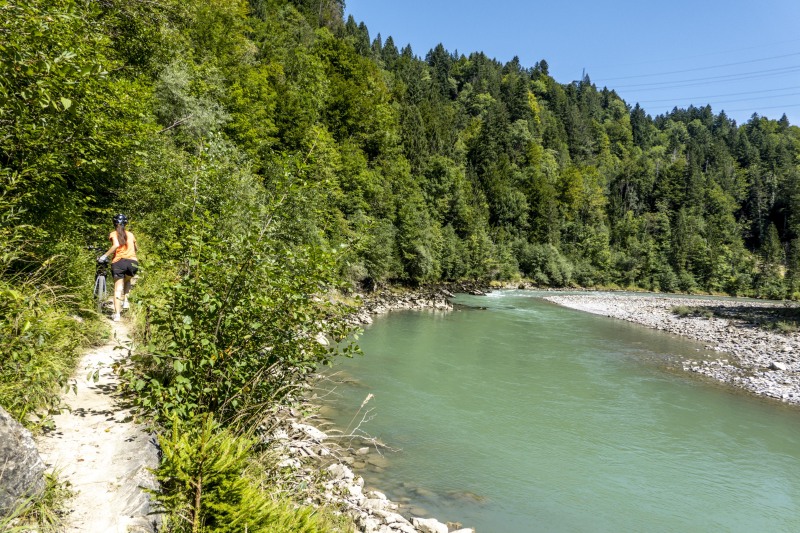 Ari pushing her bike by the river (Biking Bregenzer Ach August 2023)