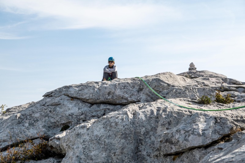 Ari sitting at the top of the climb (Climbing Croatia Oct 2022)