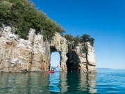 Georgia kayaking through the arch (Wainui Inlet)