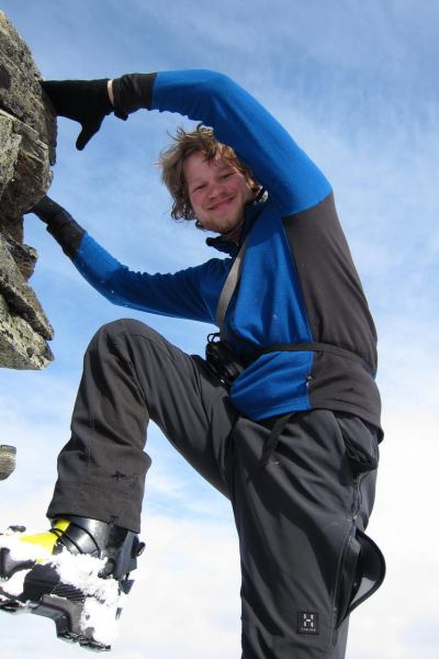 Hallvard climbing the summit cairn (Rørnestinden, Norway)