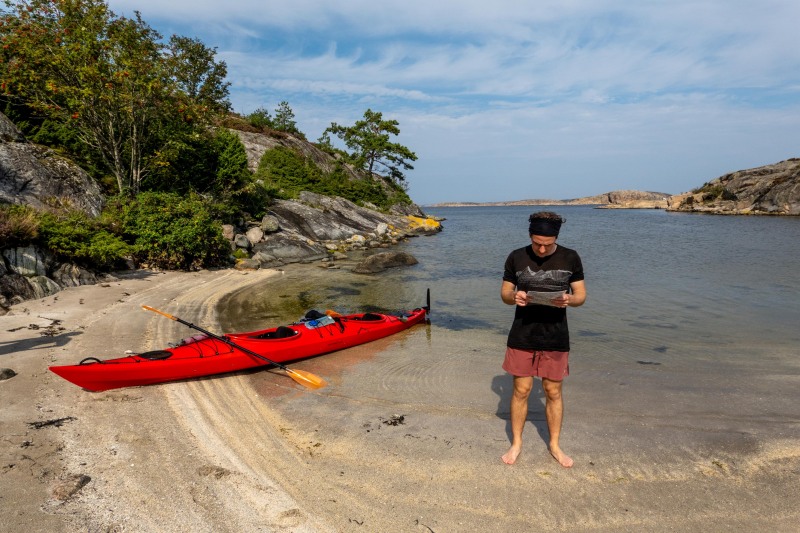 Phil checks the map beside his kayak (Seakayaking Sweden, August 2024)