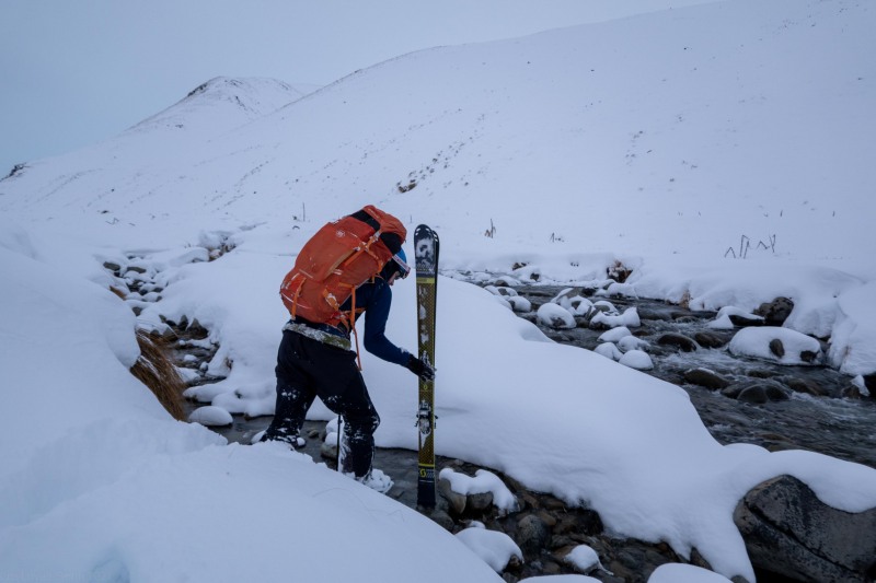 Craig crosses the river (Ski Touring Camp Stream Hut Aug 2021)