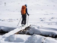 Craig crossing a little bridge (Ski touring Kirtle Burn Hut August 2021)