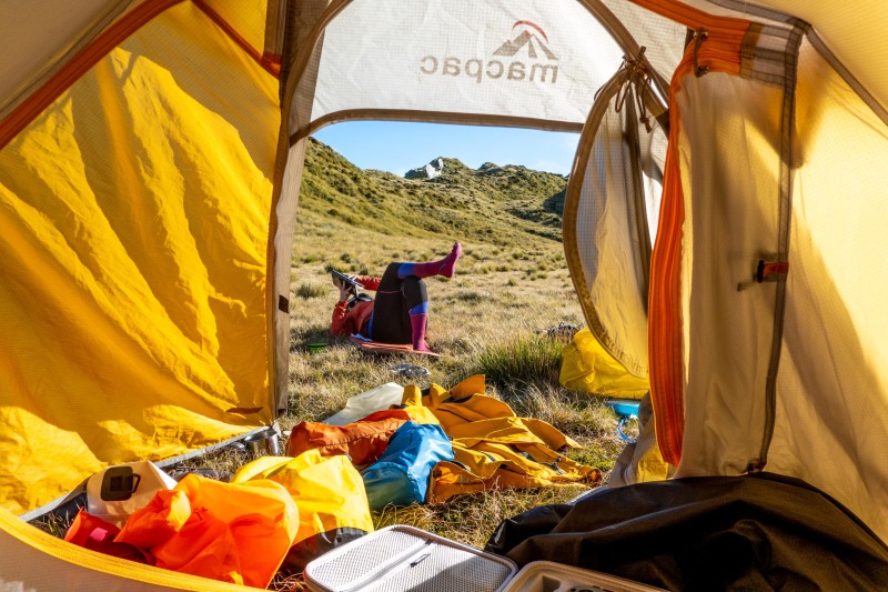 Katie lazing outside the tent (Tramping Mt Alexander Dec 2024)