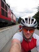 Emily and Cris are passed by a train while riding towards Oberalppass (Switzerland) resize